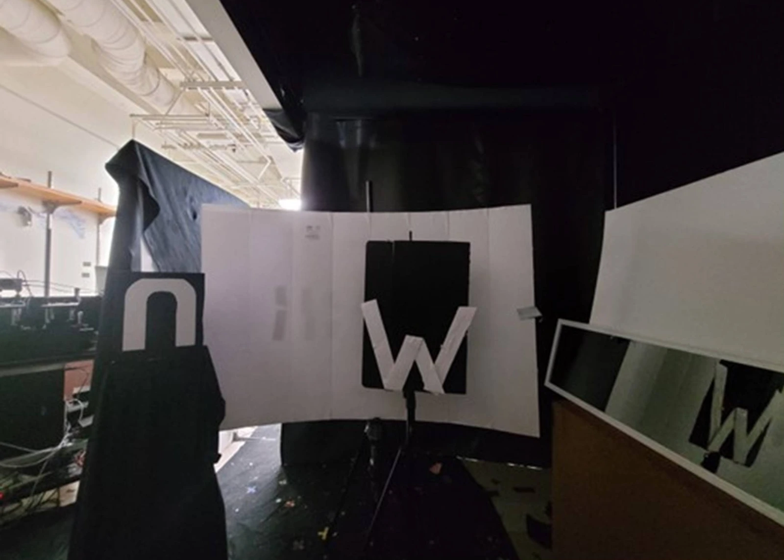 Photograph of the actual experiment: letter n at left, W in the center, a diffuse back wall, and a mirror at right.